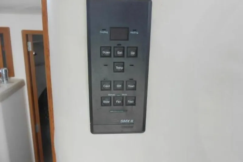 Slide: The Image of Control panel on a 1997 Riviera 34 Convertible yacht, featuring temperature and fan settings. - 33