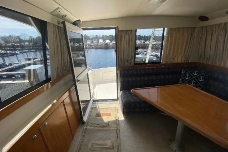 Slide: The Image of Interior of 1997 Riviera 34 Convertible yacht with dining area and marina view. - 40