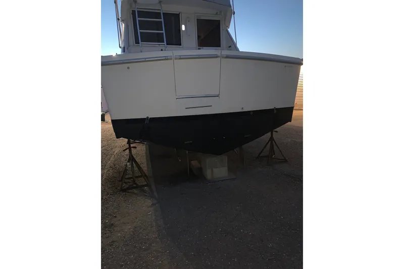 Slide: The Image of 1997 Riviera 34 Convertible boat on stands, rear view, in a storage area. - 9