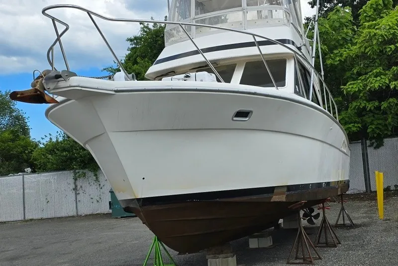 Slide: The Image of 1997 Riviera 34 Convertible boat on stands, outdoor setting, clear sky background. - 13