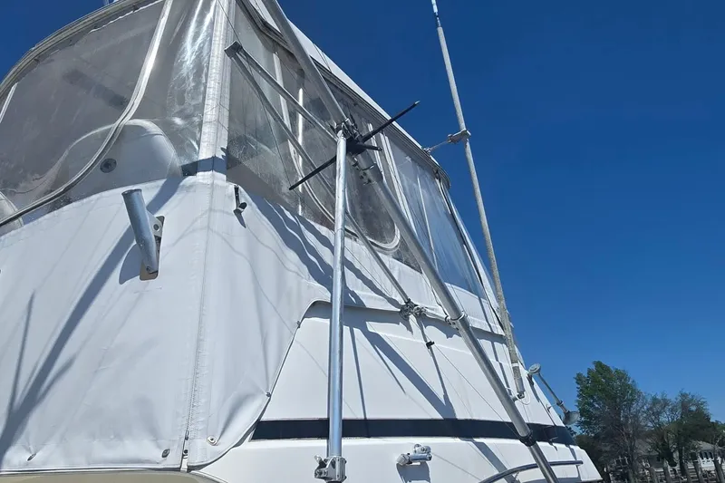 Slide: The Image of 1997 Riviera 34 Convertible boat with clear canopy against blue sky. - 24