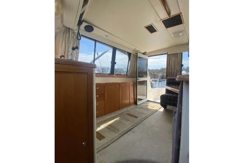Slide: The Image of Interior of 1997 Riviera 34 Convertible yacht with wooden cabinetry and large windows. - 37