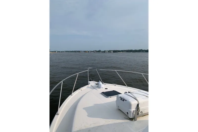 Slide: The Image of Bow view of 1997 Riviera 34 Convertible yacht on calm waters. - 27