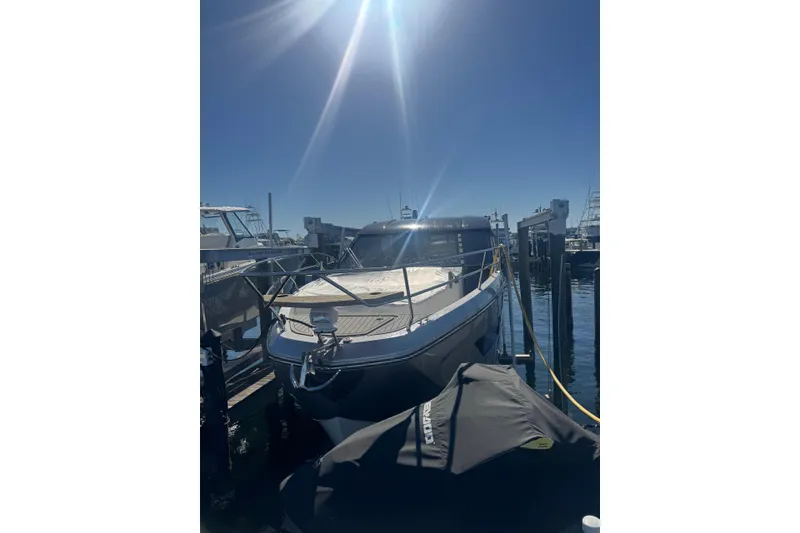 Slide: The Image of 2025 Hanover 387 boat docked under bright sunlight at a marina. - 2