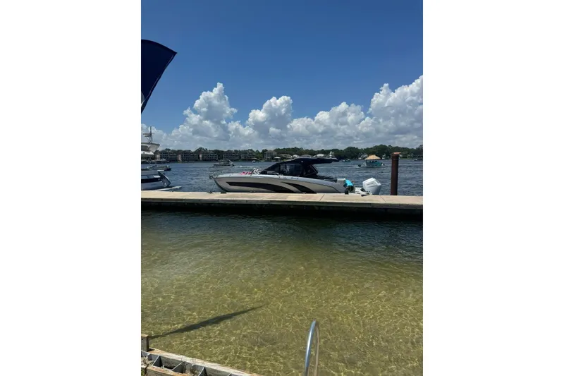 The Image of 2025 Hanover 387 boat docked by a scenic waterfront under a clear blue sky. - 0