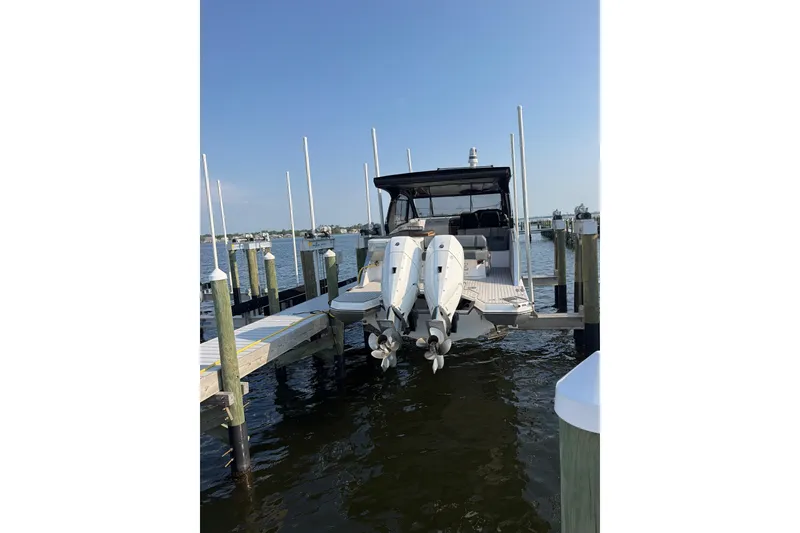 Slide: The Image of 2025 Hanover 387 boat docked with dual outboard motors on a sunny day. - 1