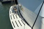 Slide: The Image of 1978 Hatteras 43 Double Cabin yacht docked, showcasing rear deck and water reflection. - 3