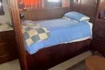 Slide: The Image of 1978 Hatteras 43 Double Cabin interior with cozy bed and wooden furnishings. - 8