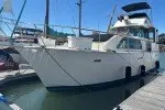Slide: The Image of 1978 Hatteras 43 Double Cabin yacht docked at marina under clear blue sky. - 1