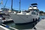 The Image of 1978 Hatteras 43 Double Cabin yacht docked at marina under clear blue sky. - 0