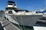 Slide: The Image of 1978 Hatteras 43 Double Cabin yacht docked at a marina under clear blue skies. - 2