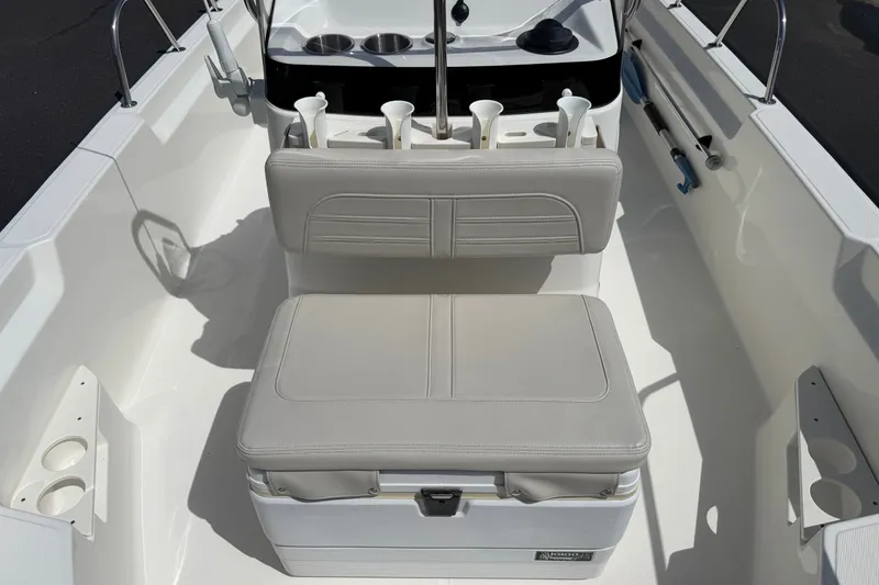 Slide: The Image of 2022 Boston Whaler 170 Montauk interior with cushioned seating and rod holders. - 6