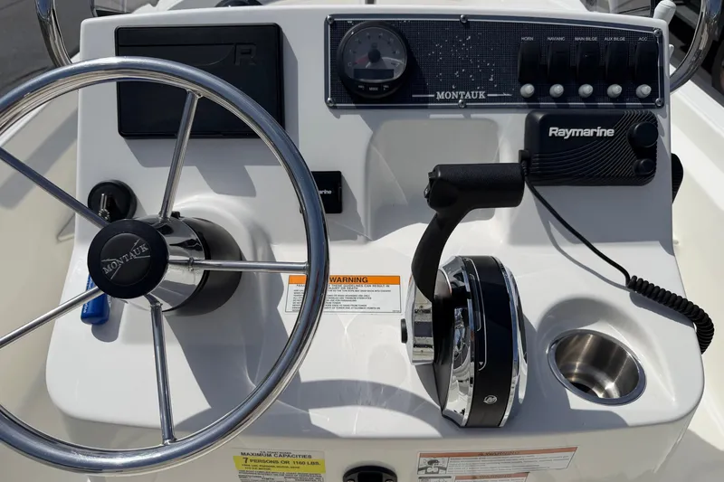 Slide: The Image of 2022 Boston Whaler 170 Montauk boat dashboard with steering wheel and controls. - 12
