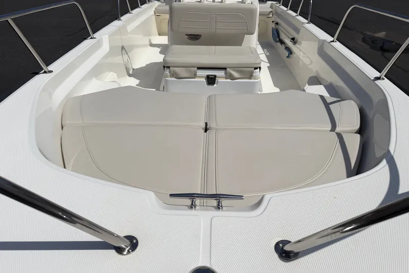 Slide: The Image of 2022 Boston Whaler 170 Montauk boat interior with cushioned seating and stainless steel railings. - 5