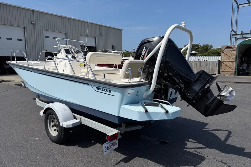 Slide: The Image of 2022 Boston Whaler 170 Montauk boat on trailer, parked outside a warehouse. - 2