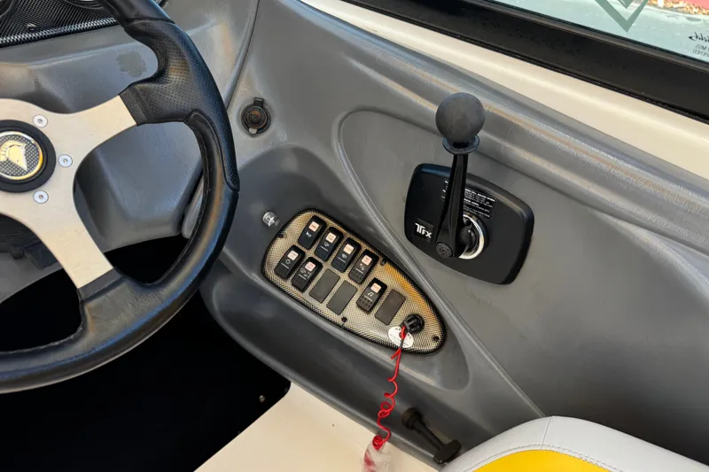 Slide: The Image of Interior controls of a 2003 Centurion Cyclone C4 boat, featuring steering wheel and throttle. - 30
