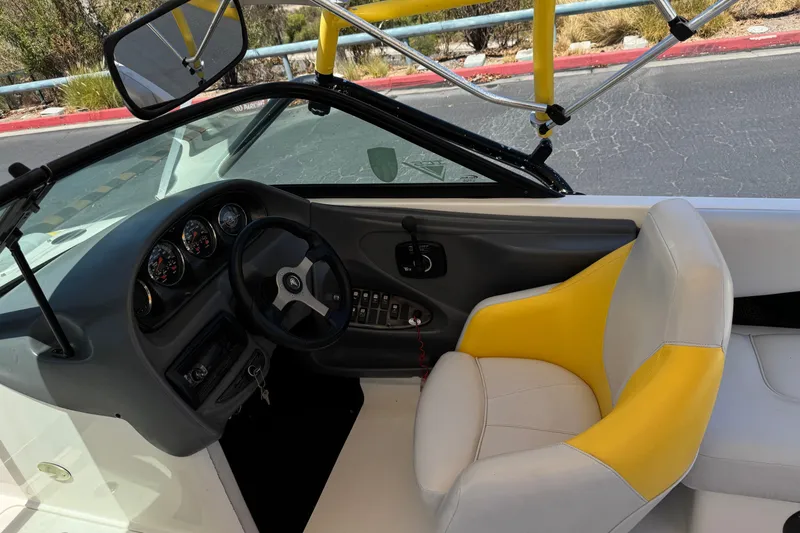 Slide: The Image of Interior of a 2003 Centurion Cyclone C4 boat with yellow-accented seating and dashboard controls. - 27