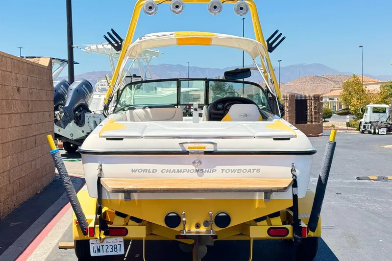 Slide: The Image of 2003 Centurion Cyclone C4 towboat, yellow and white, parked outdoors with mountain backdrop. - 4