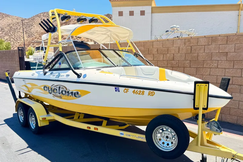 Slide: The Image of 2003 Centurion Cyclone C4 boat on trailer, yellow and white design, parked outdoors. - 1