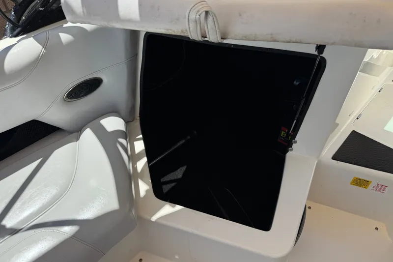 Slide: The Image of 2003 Centurion Cyclone C4 boat interior with open storage compartment and white seating. - 25