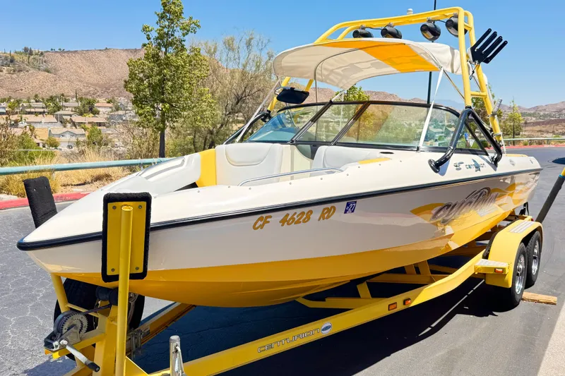 Slide: The Image of 2003 Centurion Cyclone C4 boat on trailer, yellow and white, parked outdoors. - 3