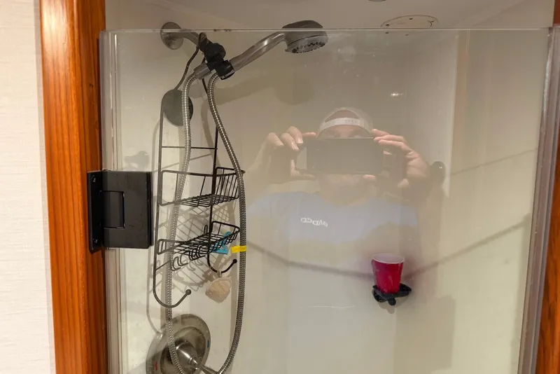 Slide: The Image of Shower interior with glass door, metal caddy, and red cup in a 1996 Post 50 Convertible. - 31