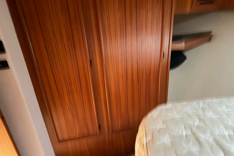 Slide: The Image of Wooden cabinet and bed inside a 1996 Post 50 Convertible yacht interior. - 25