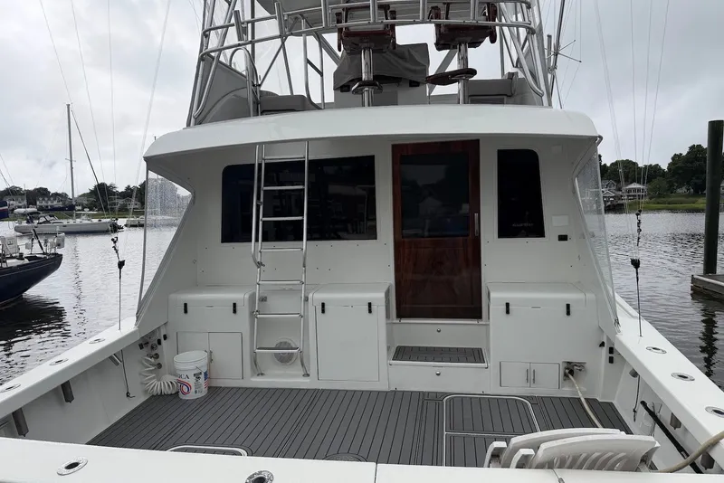 Slide: The Image of 1996 Post 50 Convertible yacht docked, featuring spacious deck and ladder access. - 3