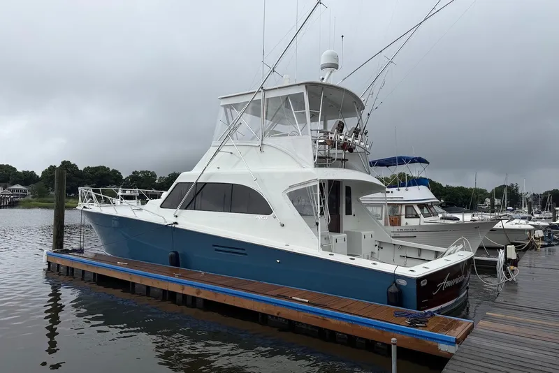 The Image of 1996 Post 50 Convertible yacht docked at marina under cloudy skies. - 1