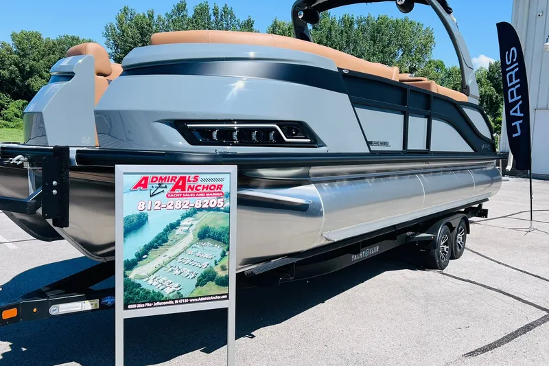 Slide: The Image of 2027 Harris Grand Mariner 250 SL pontoon boat displayed at dealership with promotional sign. - 2