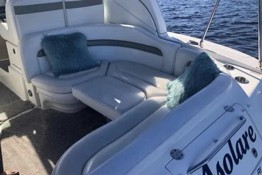 Slide: The Image of 2006 Sea Ray Sundancer 320 boat with plush seating and blue cushions on open water. - 8
