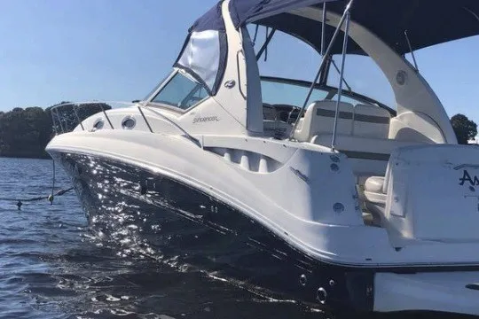 Slide: The Image of 2006 Sea Ray Sundancer 320 boat on calm water, featuring sleek design and spacious deck. - 1