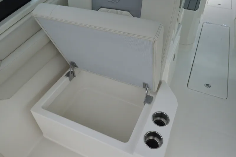 Slide: The Image of 2027 Sailfish 316 DC boat seat storage with cup holders, open compartment view. - 14