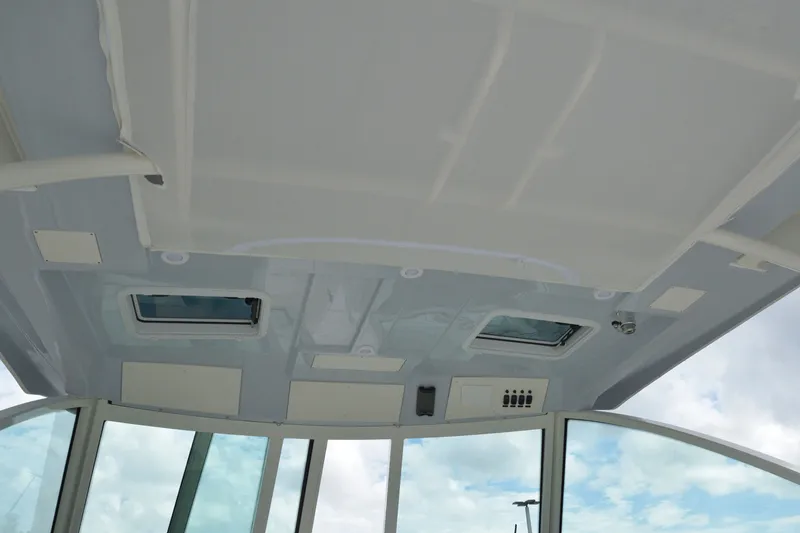 Slide: The Image of 2027 Sailfish 316 DC boat interior ceiling with windows and controls. - 18