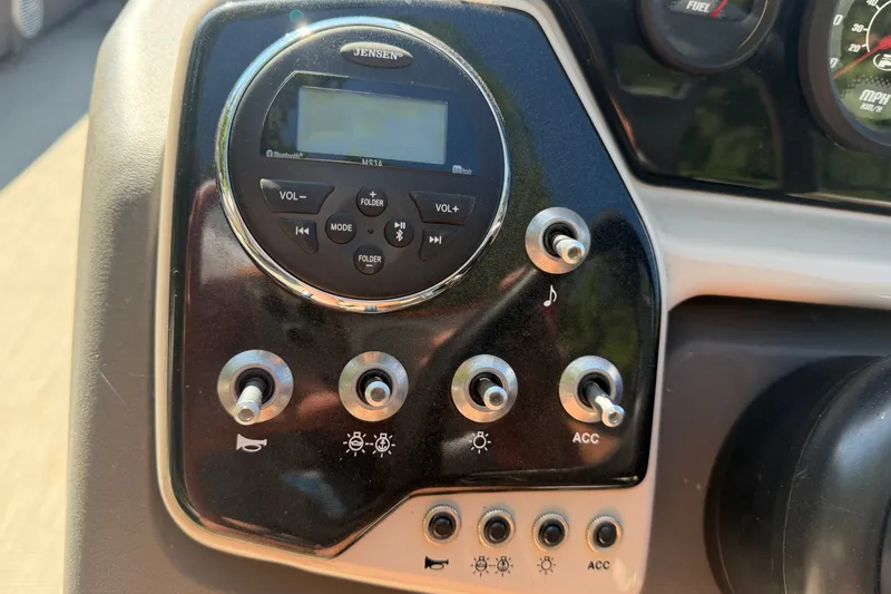 Slide: The Image of Control panel of a 2019 Princecraft Vectra 25 boat with switches and a Jensen audio system. - 24