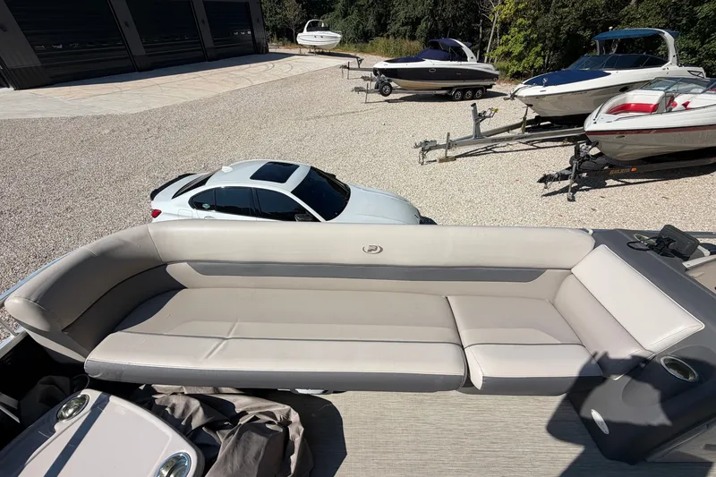 Slide: The Image of 2019 Princecraft Vectra 25 boat with beige seating, parked near other boats and a car. - 16