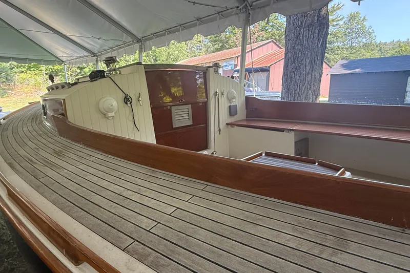 Slide: The Image of Wooden deck of a 2005 Tadome boat under a canopy, showcasing classic design. - 15