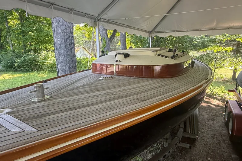 Slide: The Image of 2005 Tadome boat with wooden deck under a canopy, surrounded by lush greenery. - 13