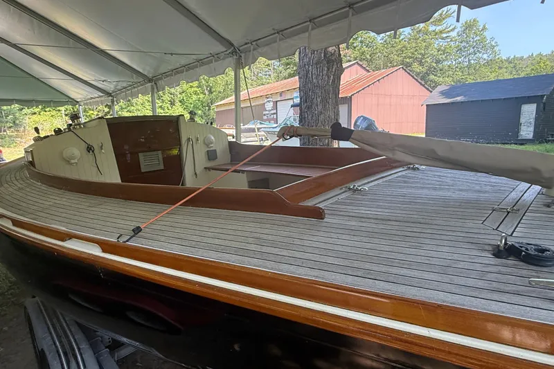 Slide: The Image of 2005 Tadome boat under canopy, showcasing wooden deck and classic design. - 14