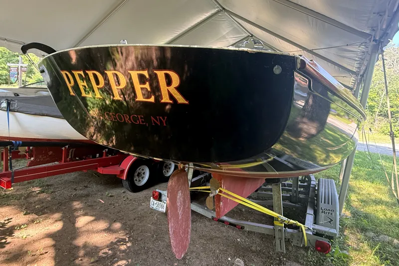 Slide: The Image of Black boat named "Pepper" from Lake George, NY, on a trailer under a canopy. - 16