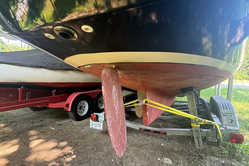 Slide: The Image of Boat hull and propeller of a 2005 Tadome on a trailer, secured with yellow straps. - 17