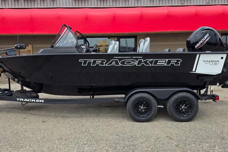 The Image of 2027 Tracker Targa V-18 Combo boat on trailer, black exterior, parked outside. - 1