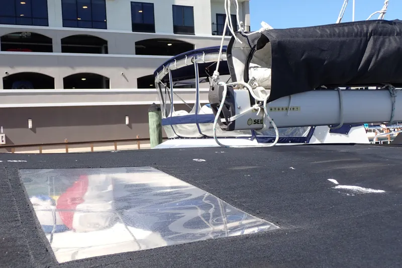 Slide: The Image of 2018 Jeanneau Sun Odyssey 389 sailboat deck with covered boom, docked near a building. - 46