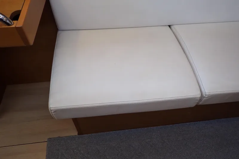 Slide: The Image of White cushioned seating on 2018 Jeanneau Sun Odyssey 389 yacht interior. - 126