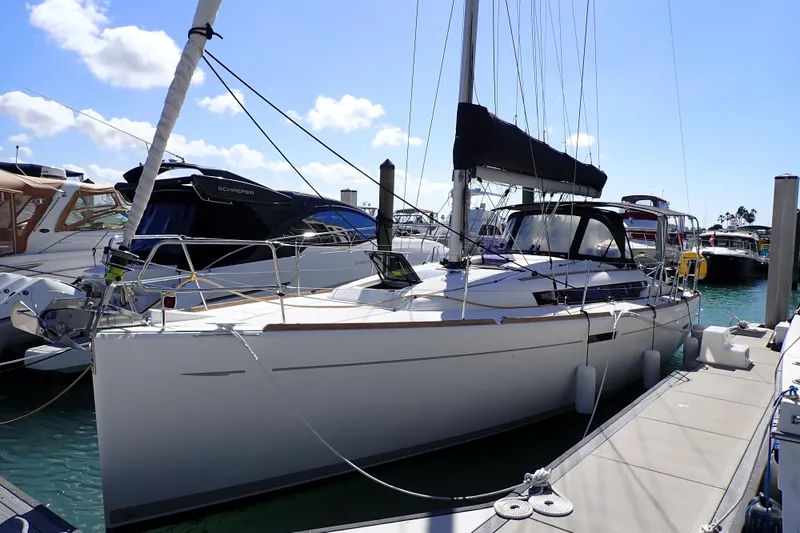 The Image of 2018 Jeanneau Sun Odyssey 389 sailboat docked at marina under clear blue sky. - 0