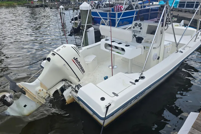 Slide: The Image of 2004 Sea Boss 180 Center Console boat with Johnson outboard motor docked by the water. - 30