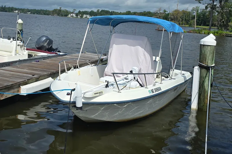 Slide: The Image of 2004 Sea Boss 180 Center Console boat docked with blue canopy and Minn Kota motor. - 4