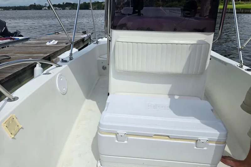 Slide: The Image of 2004 Sea Boss 180 Center Console boat interior with cooler, docked by the water. - 13