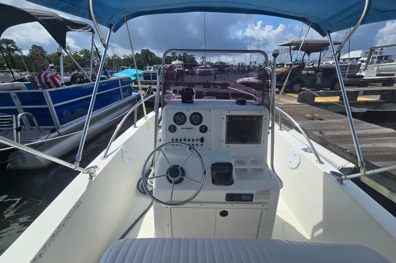 Slide: The Image of 2004 Sea Boss 180 Center Console boat with steering wheel and dashboard at marina. - 10