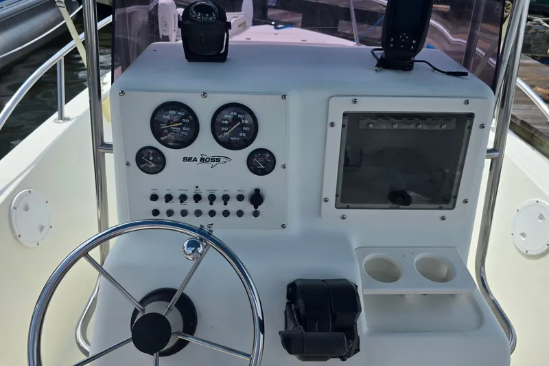 Slide: The Image of 2004 Sea Boss 180 Center Console dashboard with steering wheel and gauges. - 20